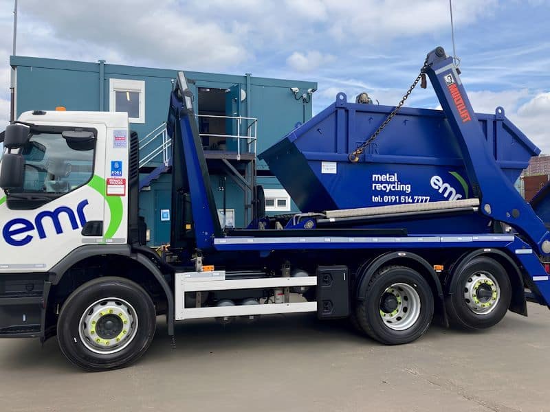 A JS Burgess fully-loaded skip being collected by a truck